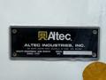 A metal nameplate for Altec Industries Inc displaying the company name address and a serial number