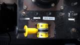 A control panel featuring various switches and labels including a yellow handle for wig wag control, situated on a surface in a vehicle