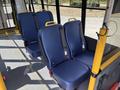 A 2018 Ford Transit-350 interior featuring several blue seating options with yellow grab handles arranged in rows