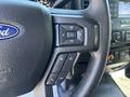 Close-up of the steering wheel controls of a 2019 Ford F-150 showing buttons for volume and media functions