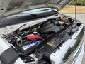 A 2014 Ford E-350 engine with various components including the battery hoses and air intake system exposed under the open hood