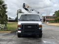 A white 2017 Ford Econoline van with a raised bucket lift attached to the roof facing forward