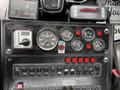 A dashboard display of a 2013 International DuraStar 4300 featuring various gauges switches and controls showing speed fuel and other indicators