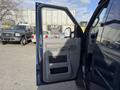 A 2011 Ford Econoline van with the driver's side door open showcasing the interior door panel and controls