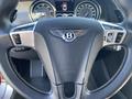 Close-up of a 2015 Bentley Continental GT steering wheel featuring the Bentley logo and various control buttons designed for luxury driving