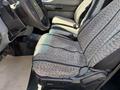The interior of a 2012 Ford F-350 SD featuring patterned cloth seats with black trim and a steering wheel with controls