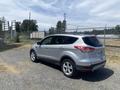 A silver 2015 Ford Escape parked with its rear facing the viewer showing its sleek design and prominent wheels
