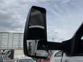 A close-up of the side mirror of a 2019 Ford F-750 truck reflecting part of the vehicle and the surroundings