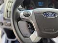 Close-up of a steering wheel from a 2018 Ford Transit featuring the Ford logo and control buttons