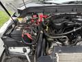 Engine compartment of a 2012 Ford F-450 SD showing the battery and various engine components with wires and hoses connected