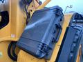 A black protective case attached to the side of a yellow heavy machinery vehicle