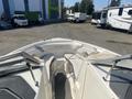 A 2013 Larson 238 boat featuring an open bow design with seating and handrails visible in the foreground