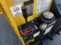 A close-up of the control panel of a 2013 Yanmar C12R-B featuring a lever, a valve, and various labels including a no smoking sign and operational instructions