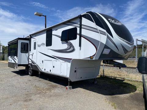 A 2021 Grand Design Recreational ST3478MBS travel trailer with a sleek design and multiple slide-outs parked on a gravel surface
