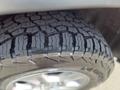 A close-up of a rugged tire from a 2015 Jeep Grand Cherokee showcasing deep treads designed for off-road traction