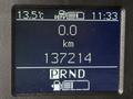 A digital dashboard display showing temperature at 13.5°C odometer reading at 137214 km and gear indicator with PRND options