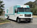 A teal and white 2020 Freightliner MT45 food truck with large windows and a stainless steel front grille parked on a flat surface