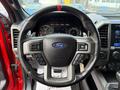 Steering wheel of a 2019 Ford F-150 featuring a black leather cover and silver accents with control buttons and the Ford logo in the center