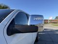 A close-up of the side mirror of a 2023 RAM 3500 showcasing its chrome finish and integrated lights