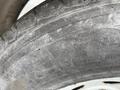 A close-up of a worn tire from a 2011 Hightliner Aquacide Hot Water Weed Control Dual Flat Deck Trailer showing visible tread patterns and dirt accumulation