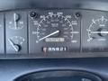 Dashboard of a 1995 Ford F-250 showing speedometer fuel gauge and odometer readout at 136907.6 kilometers