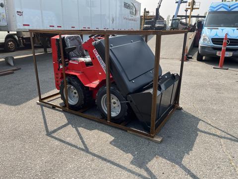 A red 2025 AGT Industrial SDA-140WZ with a black bucket is positioned in a protective metal frame