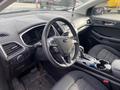 Interior view of a 2017 Ford Edge featuring a steering wheel dashboard climate controls and gear shift with fabric seats