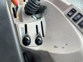 Close-up of the control levers and dashboard of a 2010 Kubota M6040 tractor showing two black levers and a textured surface