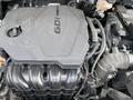 2022 Kia Sorento engine with a black plastic cover labeled GDI displaying various mechanical components and hoses