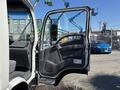 A 2016 Isuzu NPR-HD with an open driver's side door showcasing the interior and dashboard area