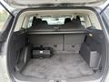The rear storage area of a 2014 Ford Escape with a black toolbox and a retractable cover over the cargo space