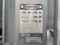 A warning label attached to a silver metal surface with instructions for safe unloading of a Freightliner 114SD dump body