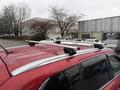 A red 2016 Mitsubishi Outlander with a silver roof rack is shown from a high angle, showcasing the vehicle's design and features