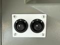 The image shows a control panel featuring two black rotary knobs with markings and a white mounting plate secured by silver screws