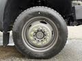 Close-up of a wheel and tire from a 2016 Ford F-550 Super Duty featuring a metallic gray rim and large rugged tire with visible tread pattern and lug nuts