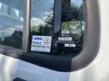 A close-up of the rear window of a 2019 Freightliner M2 106 showing vehicle restriction and approval stickers with visible water droplets on the glass