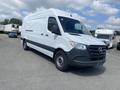 A 2025 Mercedes-Benz Sprinter van with a white exterior and black lower section parked at an industrial location