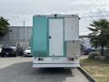 A teal and white 2020 Freightliner MT45 vehicle with a large rear door and a smaller side entrance on the right side