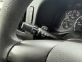 A close-up of the steering wheel and control stalk of a 2013 Chevrolet Express showing various instrument dials and control switches