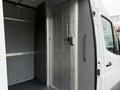Interior view of a 2023 Mercedes-Benz Sprinter showing a large cargo area with metal walls and a secured door leading outside