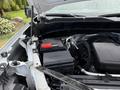 An open hood of a 2019 Chevrolet Silverado 1500 showing the engine compartment with a black battery and red terminal visible