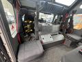 Interior of a 2006 E-One Typhoon featuring black seating with harnesses and a console area showing controls and equipment