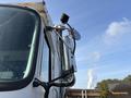 A 2011 Autocar Xpeditor truck with a prominent side mirror and a mounted camera near the front driver's side