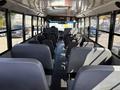 Interior view of a 2011 Freightliner B2 school bus featuring gray upholstered seats arranged in rows along the sides and an aisle down the center