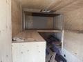 A 2009 Workhorse W62 interior showing wooden paneling and various tools and materials scattered throughout the space
