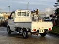 A 2008 Suzuki Carry small truck with a flatbed and a cab design featuring a rear window and a side panel configuration