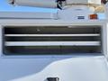 A white 2013 International 7500 truck with an open utility compartment showing two horizontal shelves inside