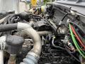 Close-up view of the engine components of a 2019 Ford F-750 featuring various hoses wires and fittings
