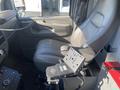 Interior of a 2011 Chevrolet Express showing a driver's seat and dashboard with controls and a mounting bracket visible beside the seat