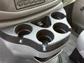 A black plastic cup holder with four circular openings designed for drinks in a 2008 Ford Econoline